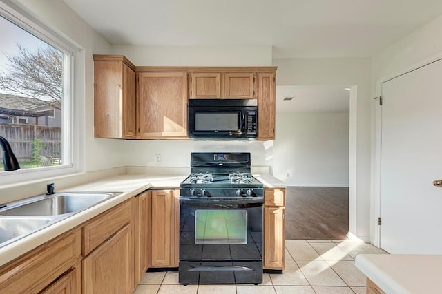 kitchen featuring plenty of natural light, black appliances, and light tile patterned flooring