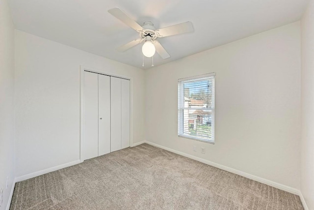 unfurnished bedroom with light carpet, a closet, and ceiling fan