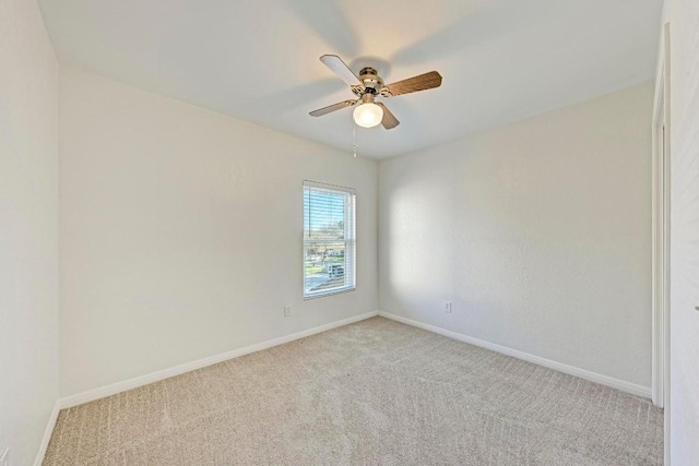 spare room featuring light colored carpet and ceiling fan