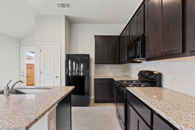 kitchen featuring light stone countertops, sink, dark brown cabinetry, and black appliances