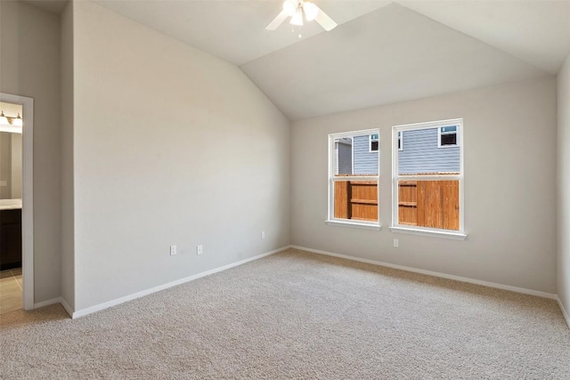 spare room featuring lofted ceiling, light colored carpet, and ceiling fan