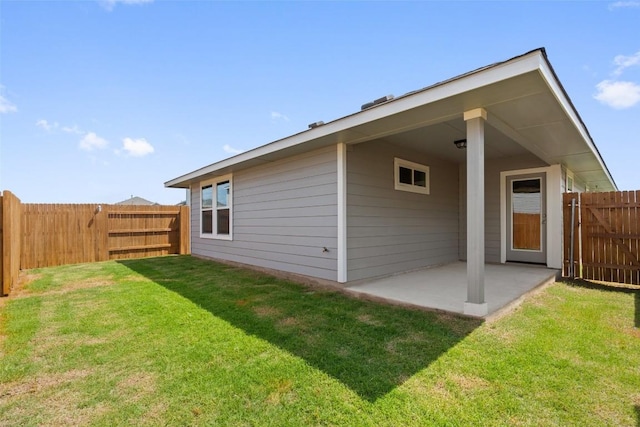 back of house with a patio and a lawn