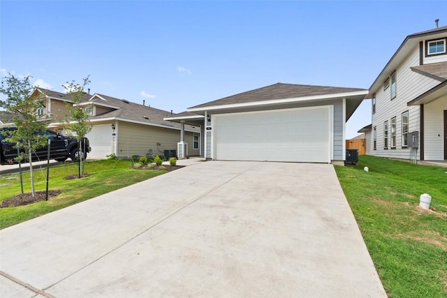 ranch-style home featuring cooling unit, a garage, and a front yard