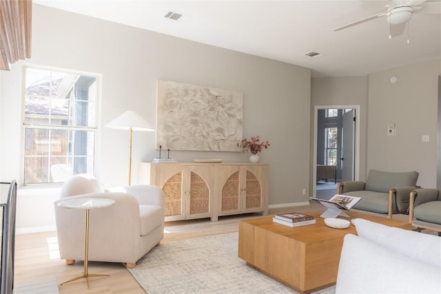 living room featuring light hardwood / wood-style floors and ceiling fan