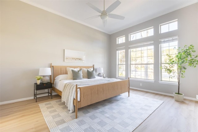 bedroom featuring crown molding, ceiling fan, and light wood-type flooring