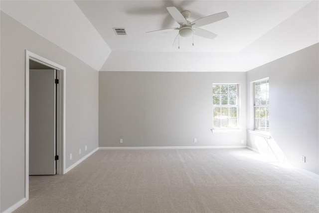 spare room with light colored carpet, ceiling fan, and a tray ceiling