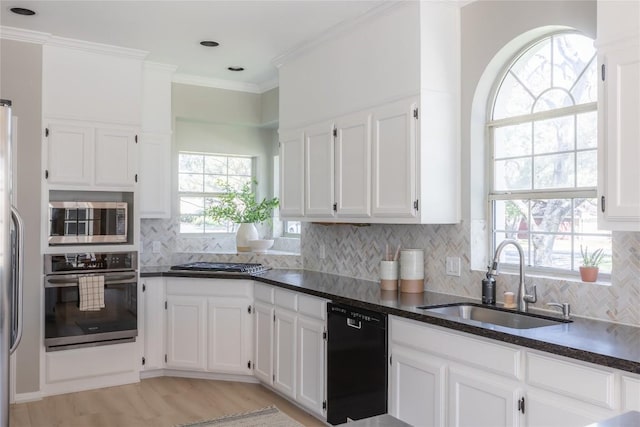 kitchen with sink, crown molding, white cabinetry, backsplash, and stainless steel appliances