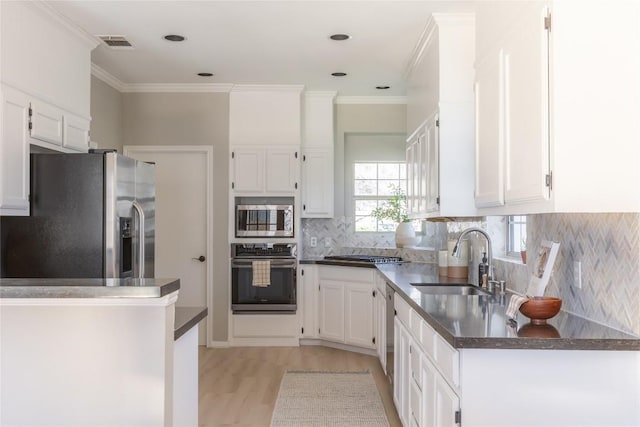 kitchen featuring sink, white cabinetry, kitchen peninsula, stainless steel appliances, and light hardwood / wood-style floors