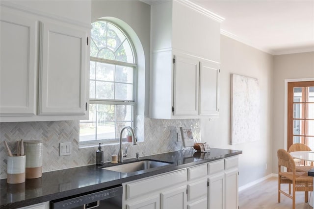 kitchen featuring sink, crown molding, black dishwasher, white cabinets, and decorative backsplash