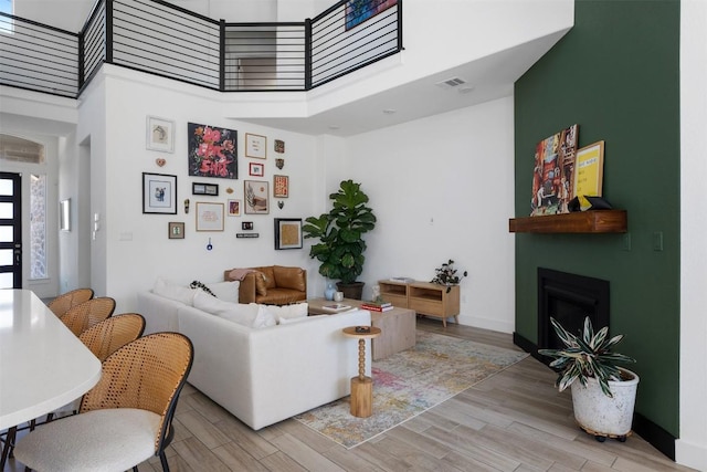 living room with a towering ceiling and light hardwood / wood-style floors