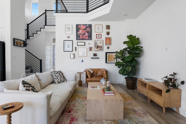 living room with a high ceiling and wood-type flooring