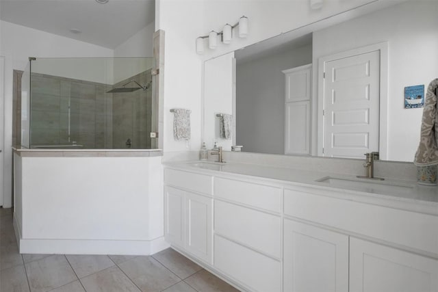 bathroom featuring walk in shower, vanity, vaulted ceiling, and tile patterned flooring