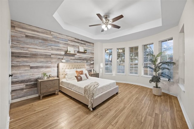 bedroom featuring ceiling fan, a raised ceiling, and hardwood / wood-style floors