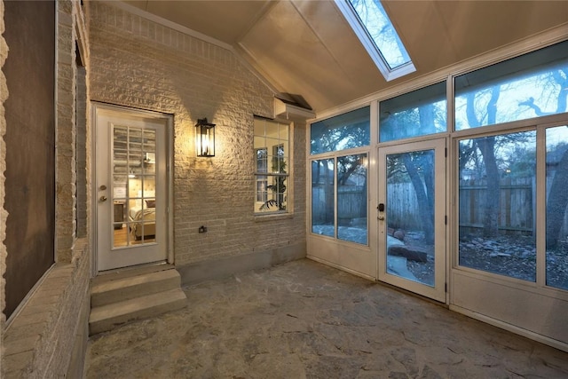 unfurnished sunroom featuring lofted ceiling with skylight