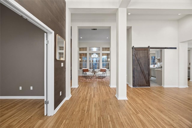 foyer entrance featuring a barn door and light hardwood / wood-style flooring