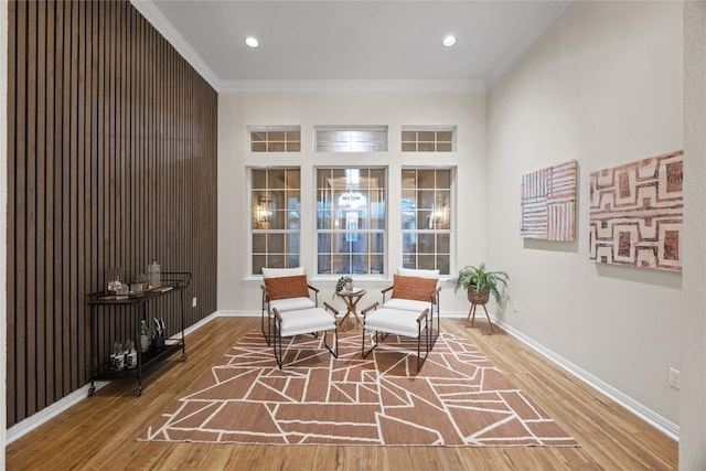 living area featuring hardwood / wood-style flooring and crown molding