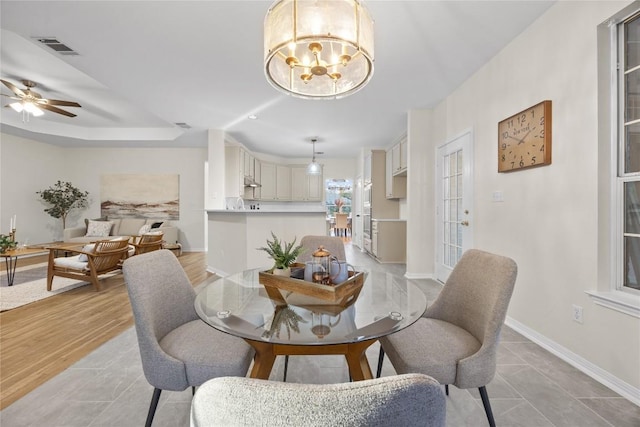 dining room featuring ceiling fan with notable chandelier