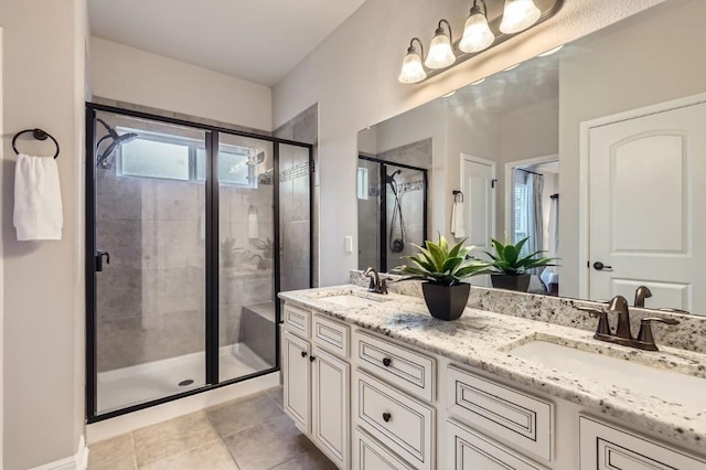 bathroom with a stall shower, a sink, and double vanity