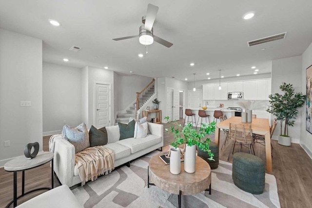 living room featuring light hardwood / wood-style flooring and ceiling fan