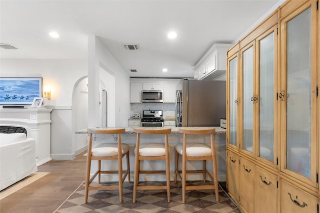 5410 Overbrook Dr, Austin, TX 78723 - kitchen featuring stainless steel appliances, recessed lighting, a breakfast bar, light wood finished floors, and a peninsula