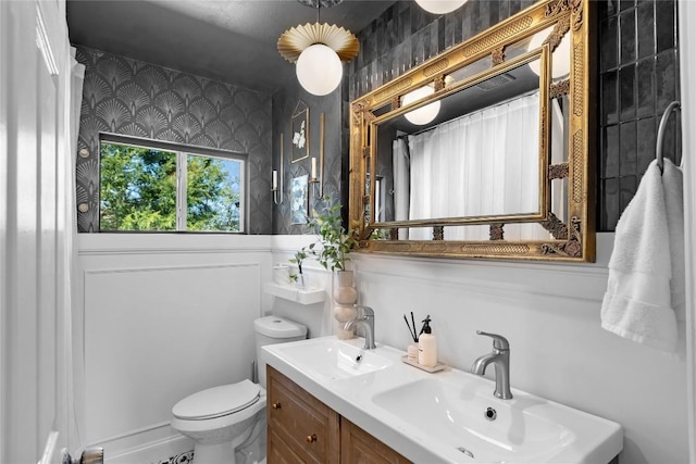 5410 Overbrook Dr, Austin, TX 78723 - bathroom featuring wallpapered walls, wainscoting, double vanity, and a shower with shower curtain