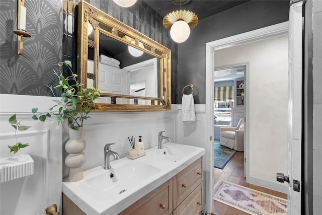 5410 Overbrook Dr, Austin, TX 78723 - bathroom featuring double vanity, a wainscoted wall, and wood finished floors