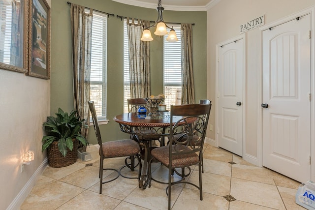 dining space with ornamental molding, light tile patterned floors, and an inviting chandelier