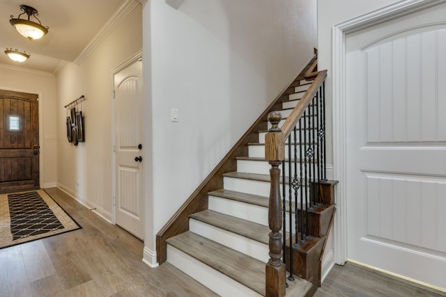 entryway featuring hardwood / wood-style flooring and ornamental molding