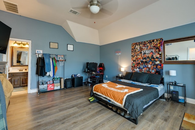 bedroom featuring hardwood / wood-style flooring, ceiling fan, lofted ceiling, and ensuite bath