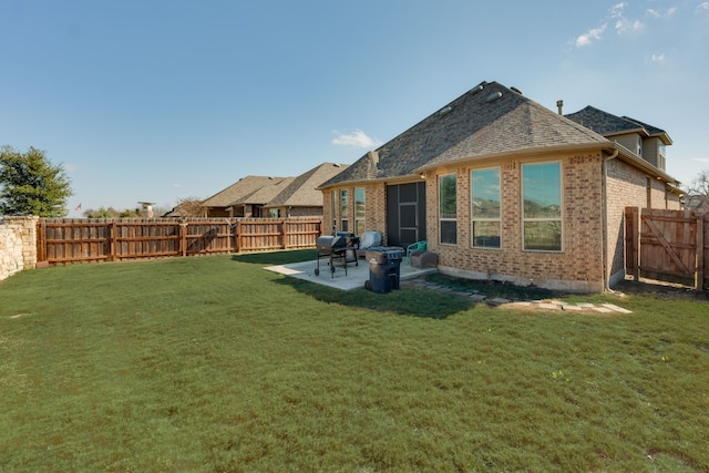 rear view of house featuring a lawn and a patio