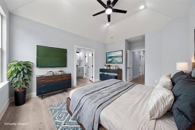 bedroom featuring lofted ceiling, ensuite bath, light hardwood / wood-style floors, and ceiling fan