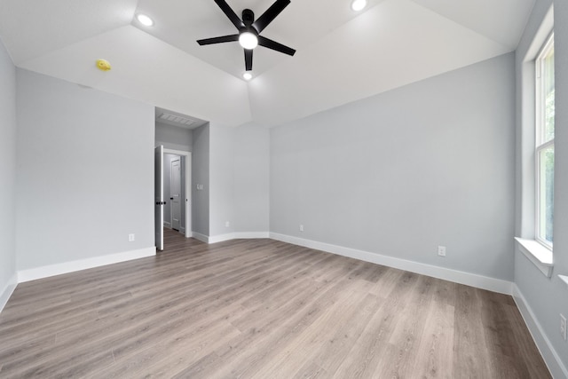 unfurnished room featuring vaulted ceiling, a healthy amount of sunlight, and light wood-type flooring