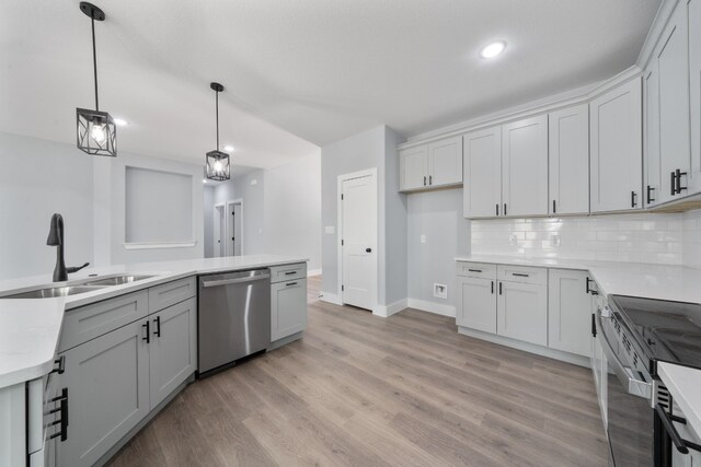 kitchen featuring appliances with stainless steel finishes, sink, decorative backsplash, hanging light fixtures, and light wood-type flooring