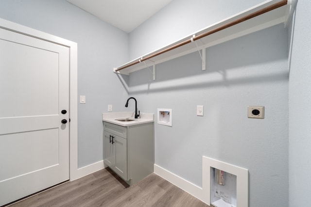 laundry area with sink, cabinets, light wood-type flooring, hookup for a washing machine, and hookup for an electric dryer