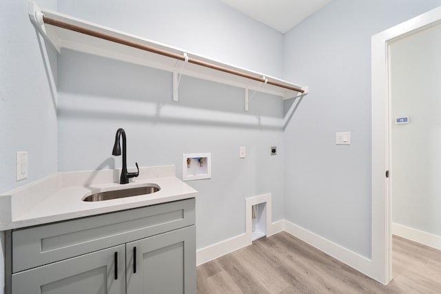 laundry room featuring sink, cabinets, light hardwood / wood-style flooring, hookup for a washing machine, and hookup for an electric dryer