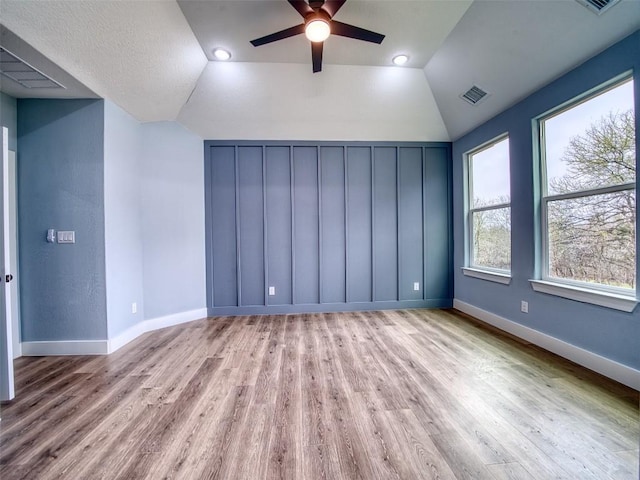 spare room featuring ceiling fan, lofted ceiling, and light hardwood / wood-style floors