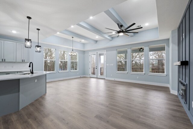 106 Halawa Ct, Bastrop, TX 78602 - unfurnished living room with ceiling fan, a chandelier, wood finished floors, recessed lighting, and beam ceiling