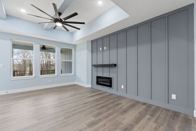 106 Halawa Ct, Bastrop, TX 78602 - unfurnished living room with ceiling fan, light wood finished floors, a tray ceiling, recessed lighting, and a large fireplace