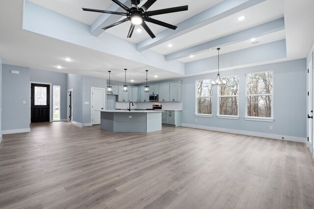 106 Halawa Ct, Bastrop, TX 78602 - kitchen featuring open floor plan, stainless steel microwave, recessed lighting, light countertops, and an island with sink