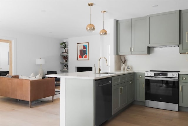 kitchen featuring appliances with stainless steel finishes, hardwood / wood-style floors, pendant lighting, sink, and kitchen peninsula