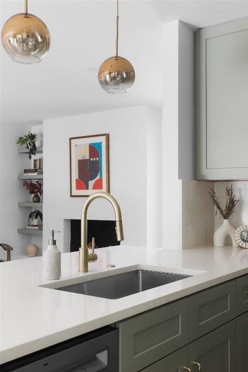 kitchen with decorative light fixtures, dishwasher, and sink