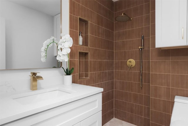 bathroom featuring vanity, toilet, and a tile shower