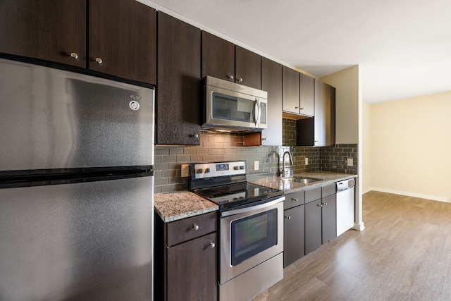 kitchen with dark brown cabinetry, sink, backsplash, and appliances with stainless steel finishes