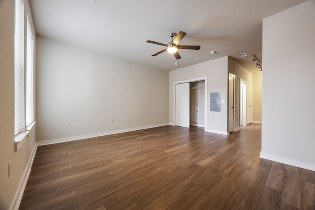 empty room featuring dark wood-type flooring, electric panel, and ceiling fan