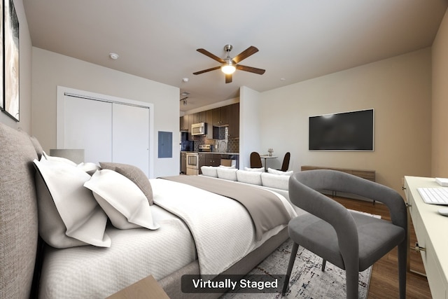 bedroom with hardwood / wood-style flooring, electric panel, ceiling fan, and a closet