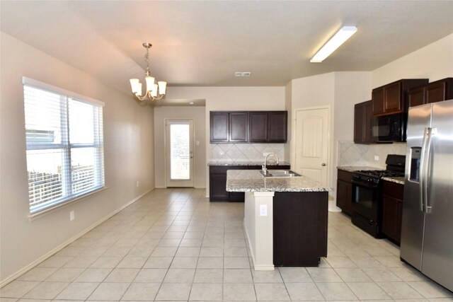 kitchen featuring decorative light fixtures, sink, a kitchen island with sink, dark brown cabinetry, and black appliances