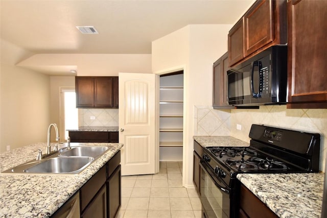 kitchen featuring sink, light tile patterned floors, tasteful backsplash, light stone counters, and black appliances