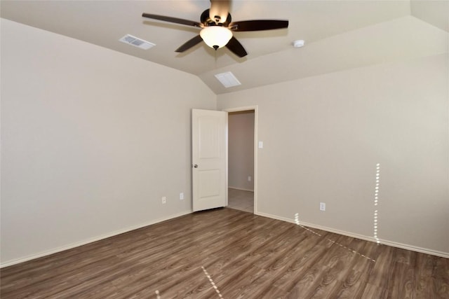 empty room featuring vaulted ceiling, dark hardwood / wood-style floors, and ceiling fan