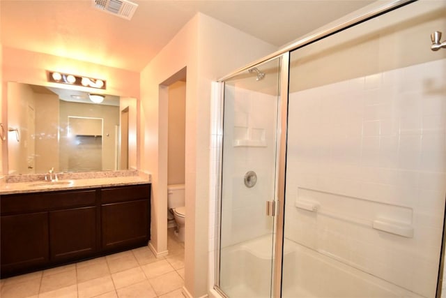 bathroom featuring vanity, tile patterned floors, a shower with door, and toilet