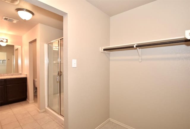 bathroom featuring tile patterned floors, vanity, toilet, and an enclosed shower